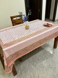 Pink and white patterned tablecloth on a wooden table.