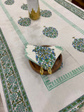 Decorative tablecloth with green and blue patterns on a white surface