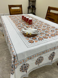 Decorative tablecloth with intricate patterns on a wooden table.