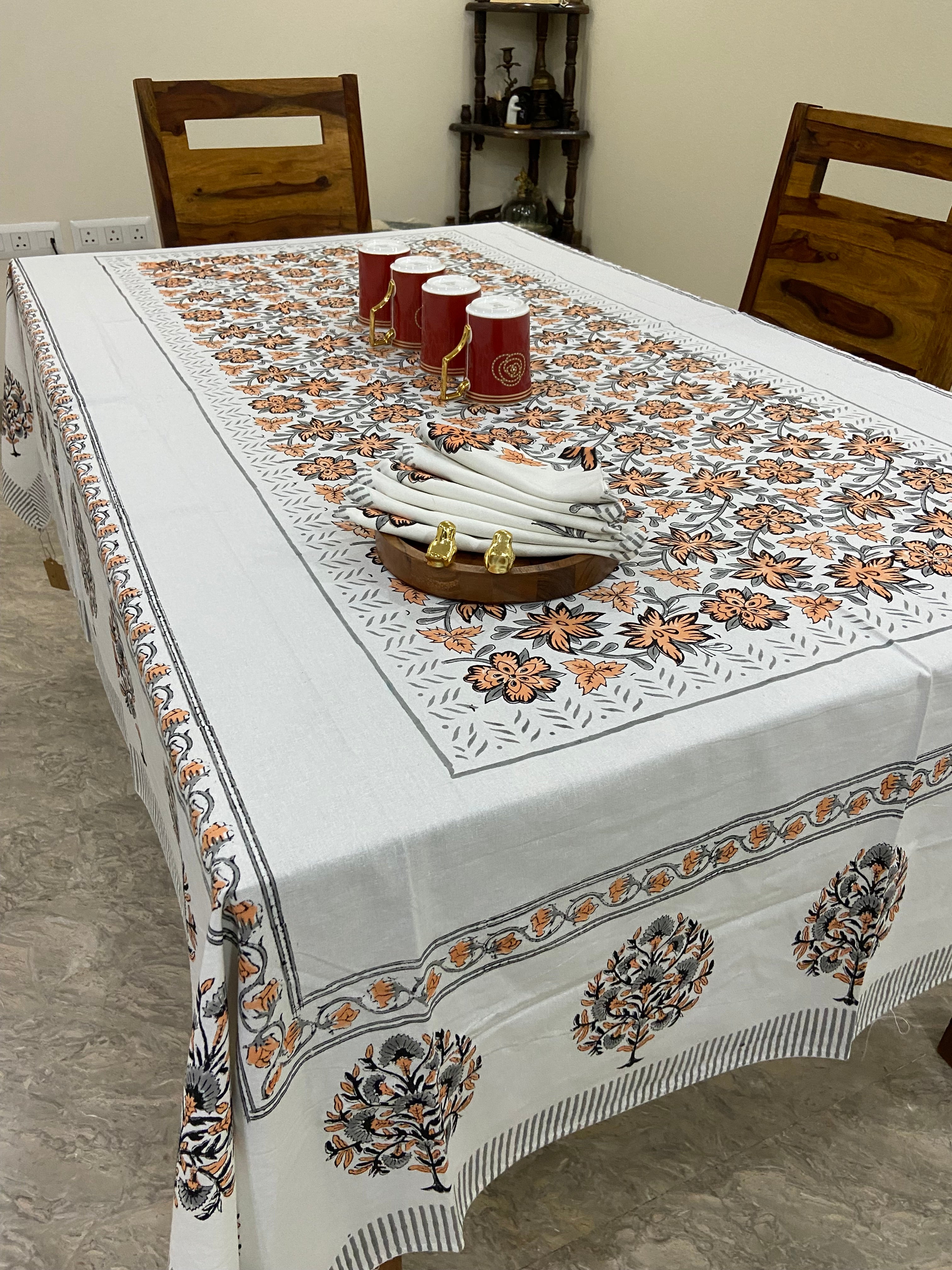 Decorative tablecloth with intricate patterns on a wooden table.