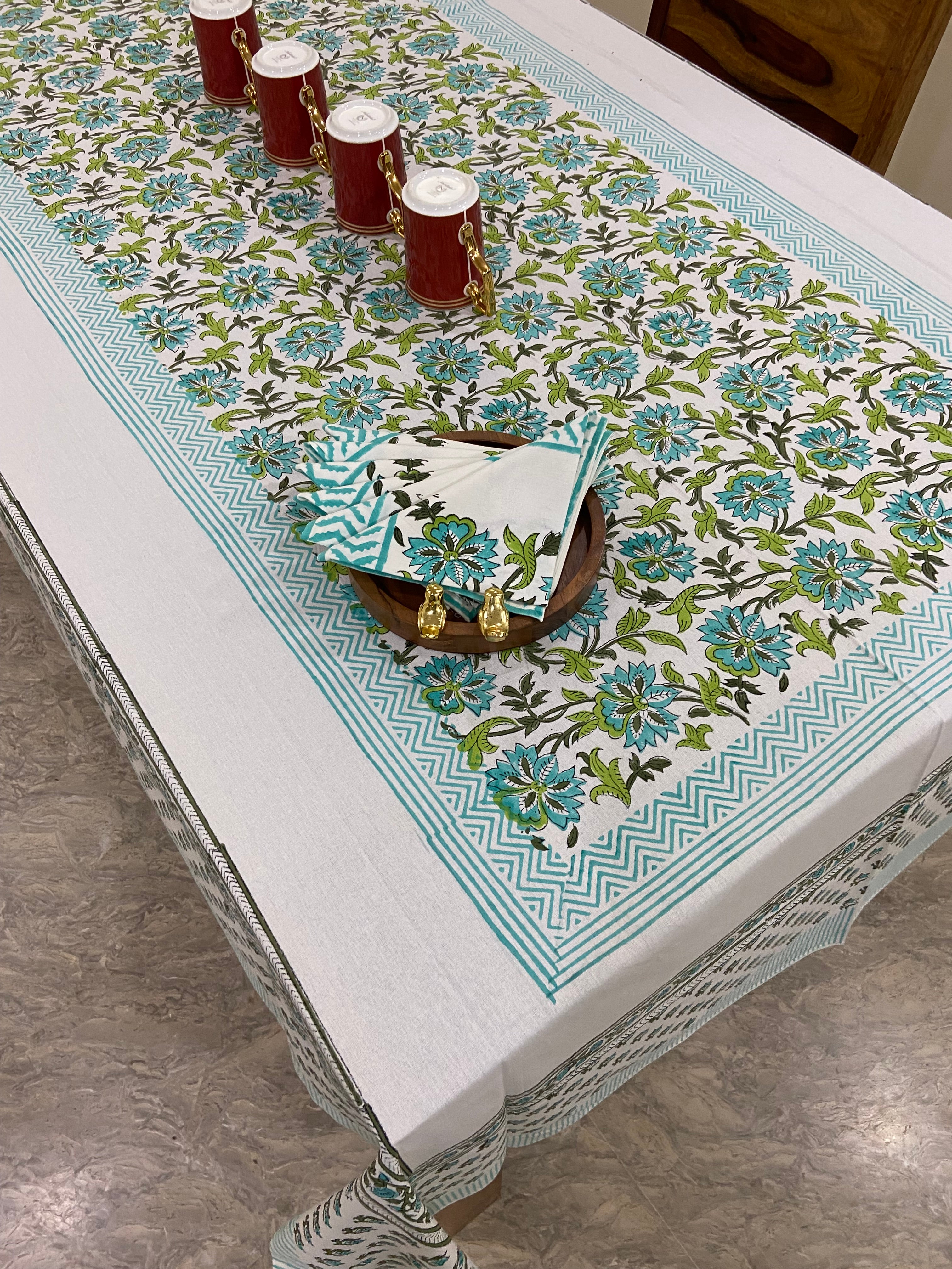 Decorative tablecloth with leafy green floral pattern on a table